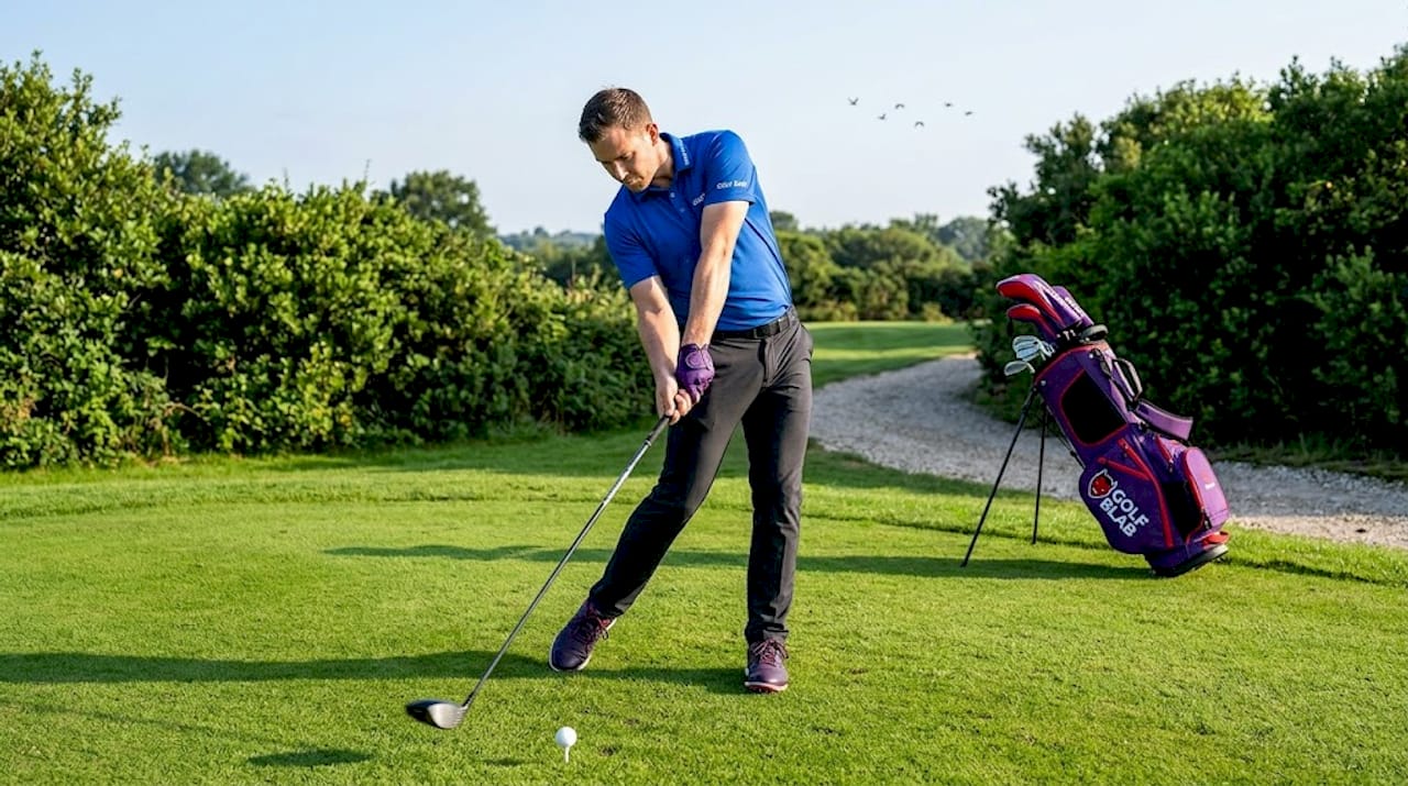Un golfista realiza su swing con mucha potencia, aprovechando la fuerza desde el suelo.