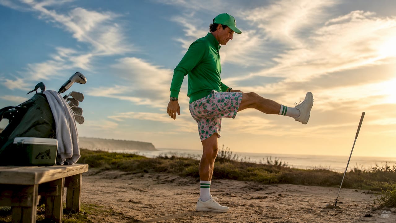 Golfer warming up with leg swings on golf course