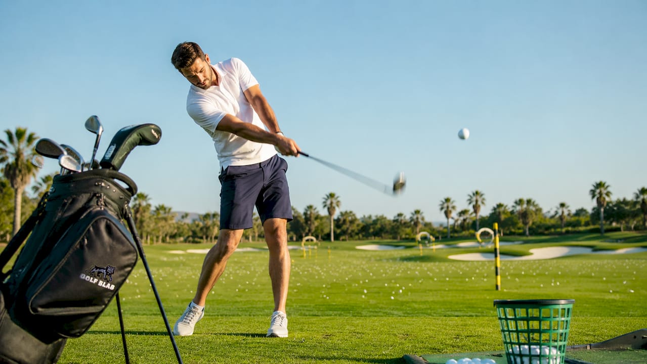 Male golfer performing powerful swing outdoors