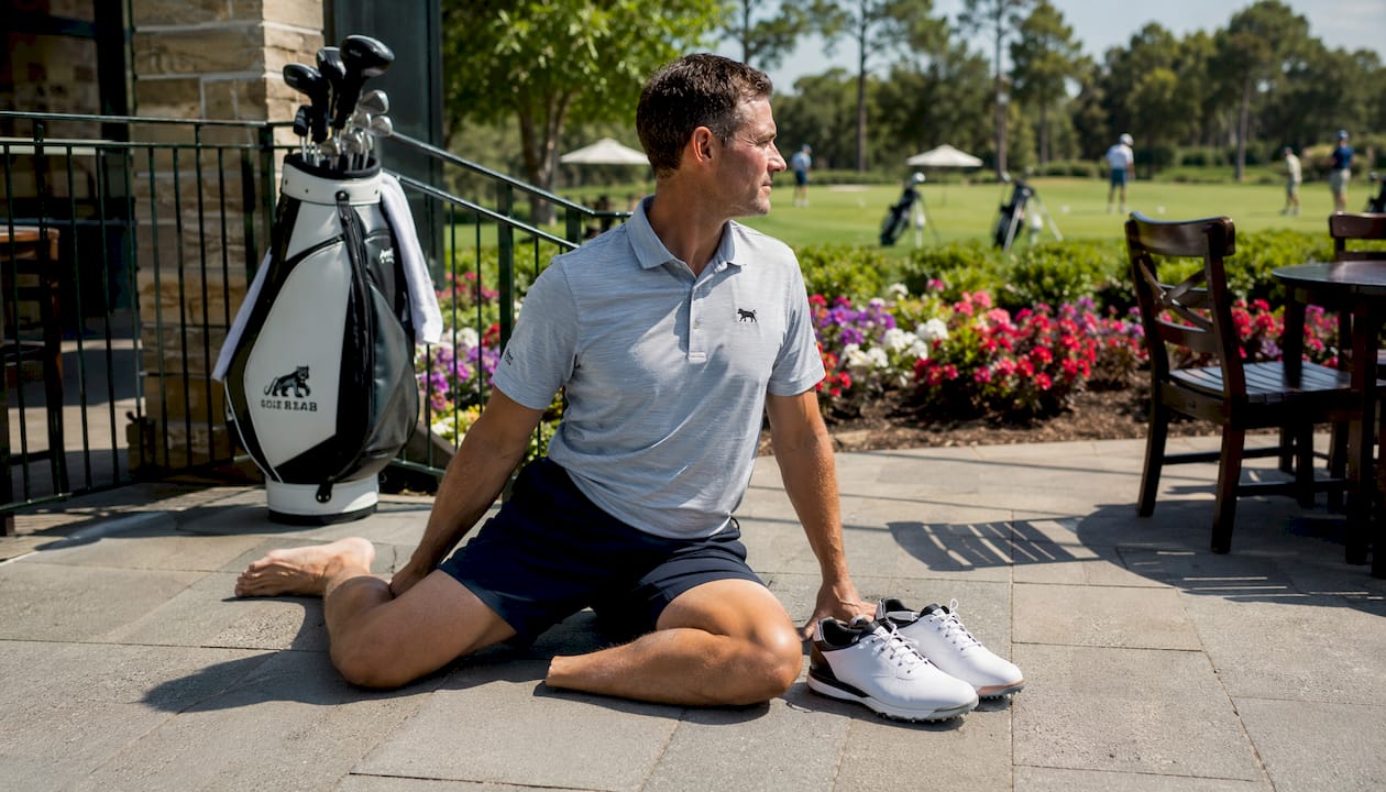 Man stretching hips on golf course grass