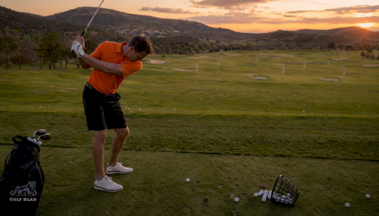 Golfer practicing golf swing tempo at driving range