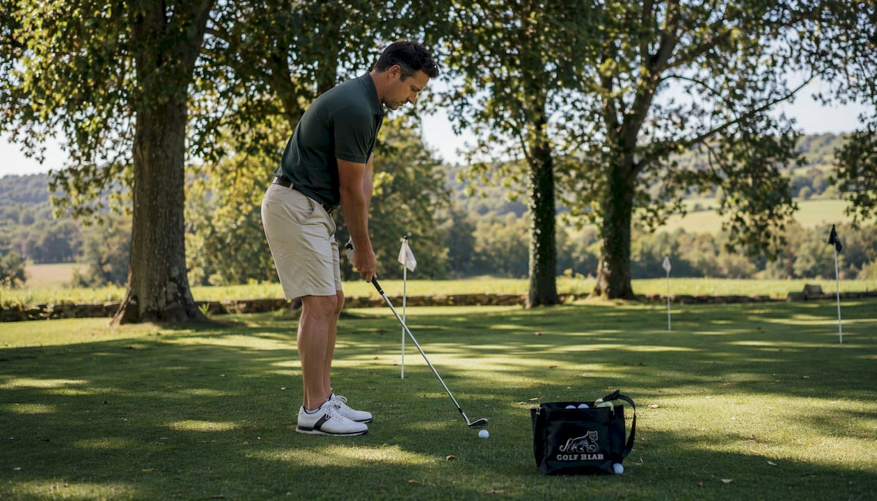 Amateur golfer practicing chip shots on green