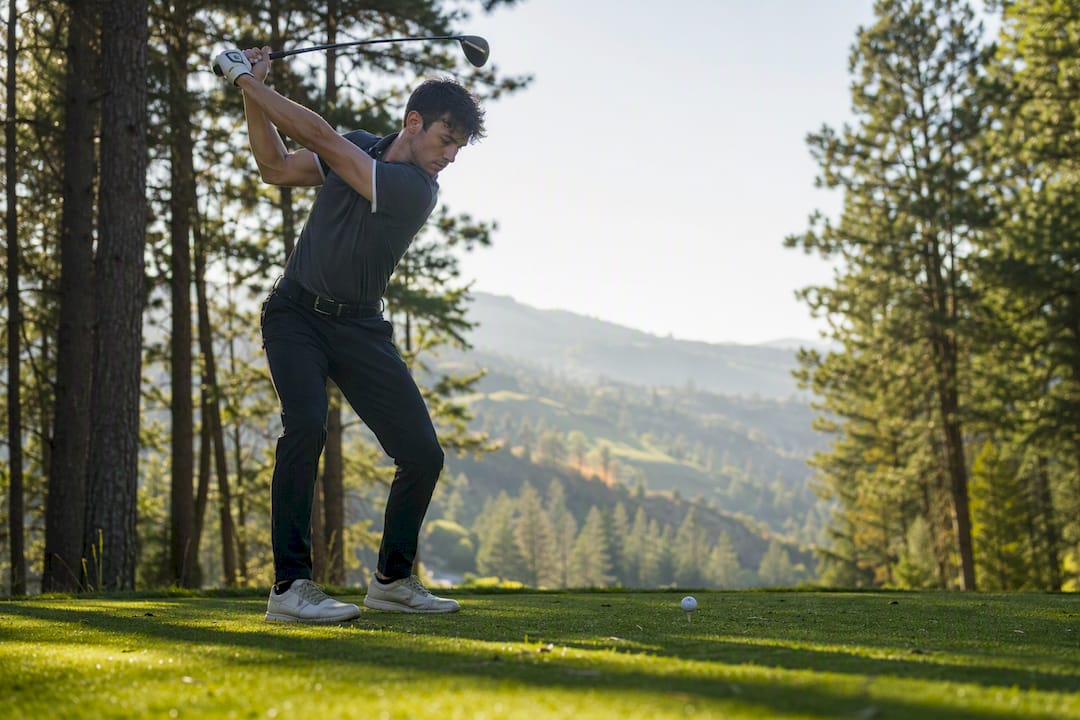 Golfer mid-backswing wearing golf polo