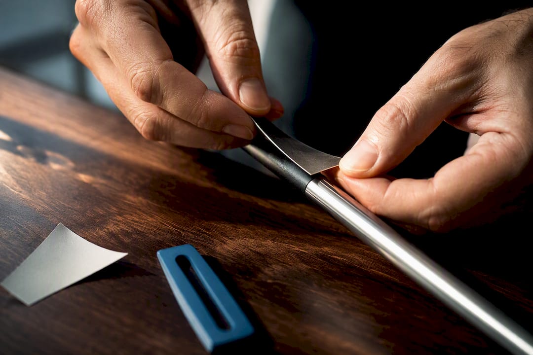 Hands applying a small golf club label