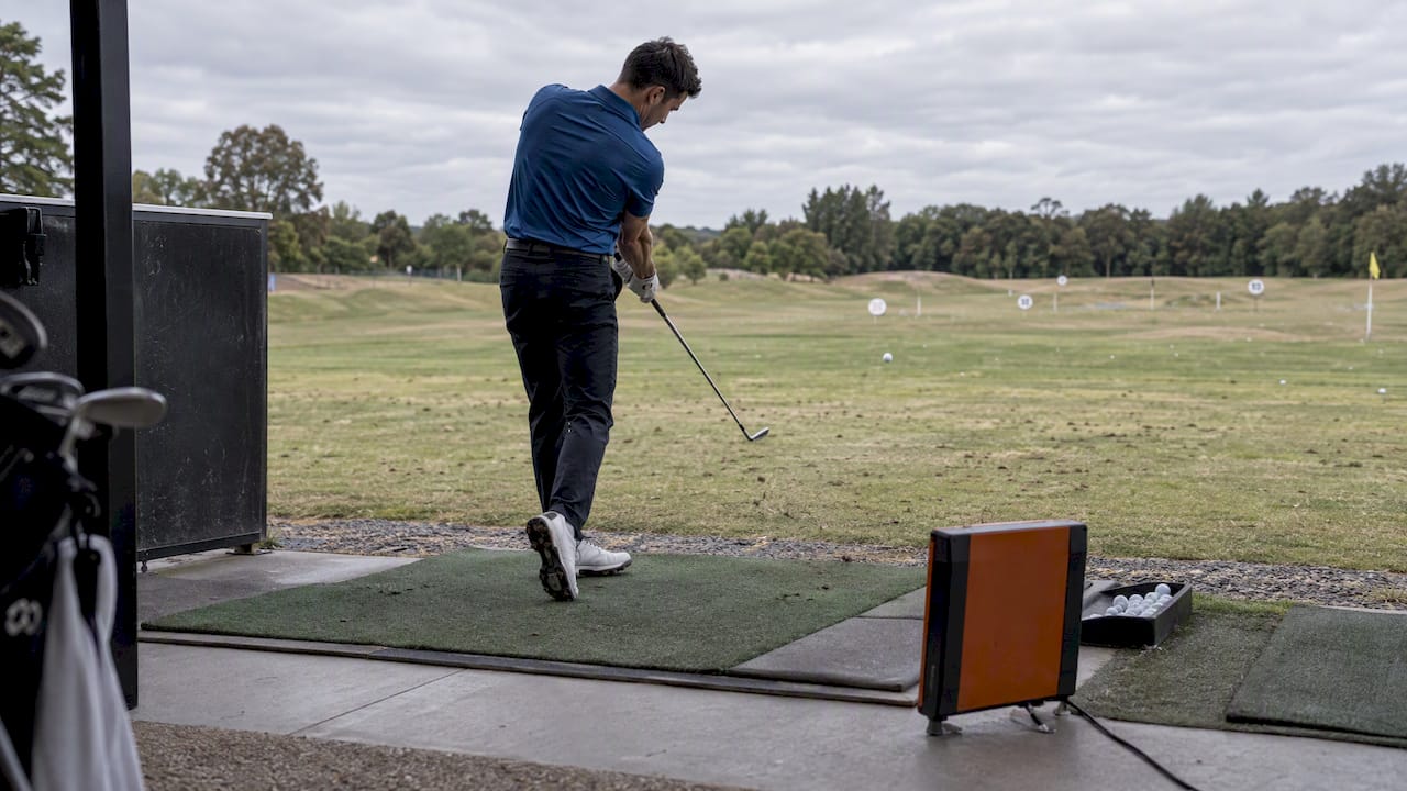 Golfer hitting a measured draw at the range